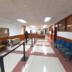 Pasillo de oficinas con accesos a despachos y mostrador al fondo