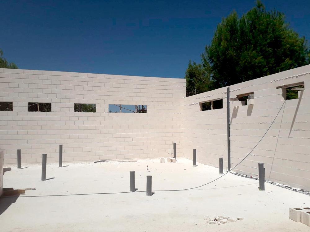 Pequeña nave en construcción, dos paredes de ladrillos sin techo