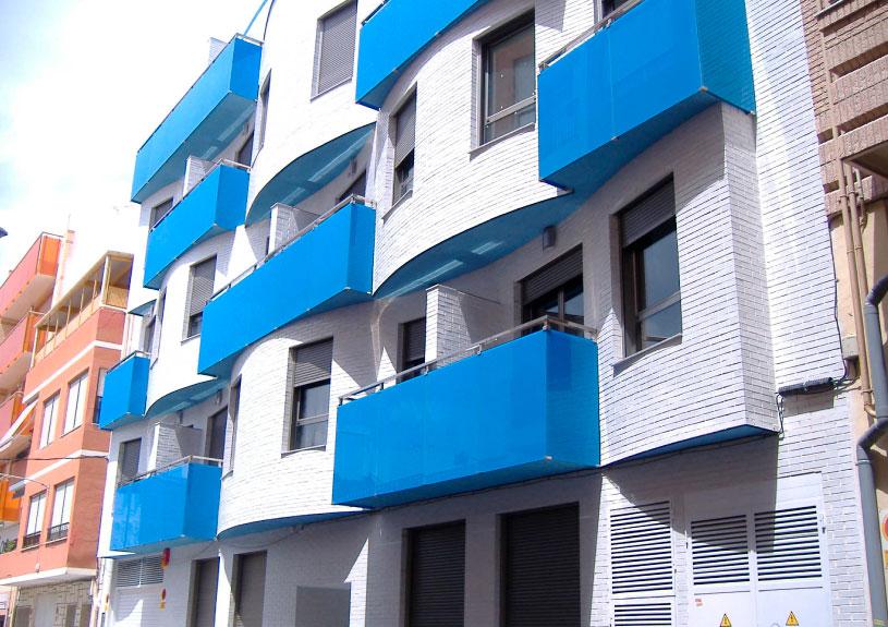 Fachada de un edificio de viviendas, en colores blanco y azul