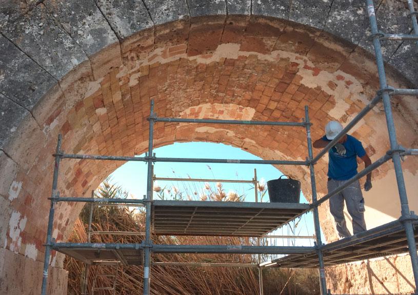 Operario sobre un andamio instalado debajo de un puente